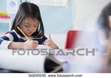 Stock Image - Girl counting with fingers and writing in notebook. Fotosearch