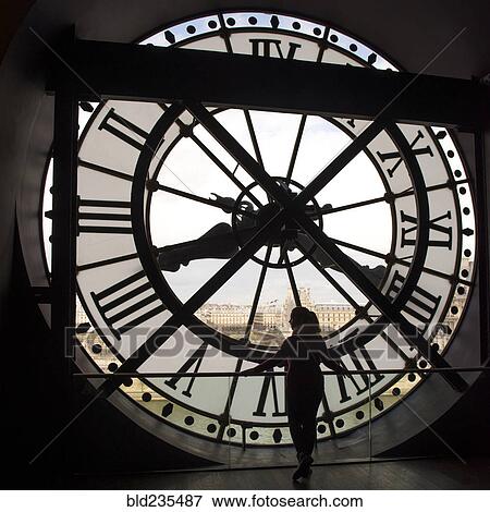 Stock Photo - Girl looking at city from behind clock. Fotosearch