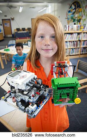 Stock Photograph - Girl posing with plastic blocks in library. Fotosearch