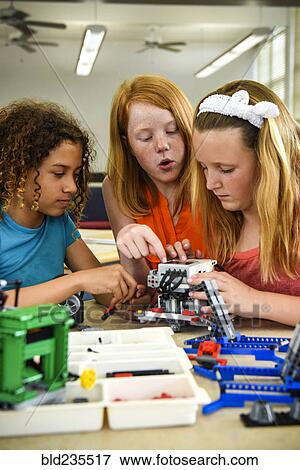 Stock Photo - Girls assembling plastic blocks in library. Fotosearch