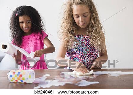 Girls cleaning spilled milk on table View Large Photo Image Stock Image - Girls cleaning spilled milk on table. Fotosearch
