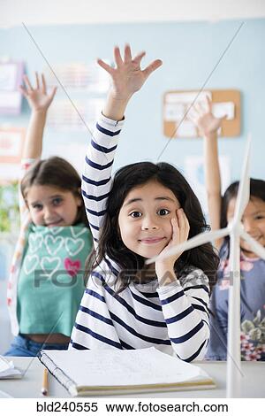 Girls learning about windmills raising hands in classroom View Large Photo Image Stock Photography - Girls learning about windmills raising hands in classroom. Fotosearch