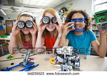 Stock Image - Girls playing with plastic blocks and wheels in library. Fotosearch