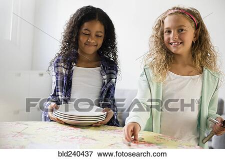 Girls setting the table for meal View Large Photo Image Stock Photo - Girls setting the table for meal. Fotosearch