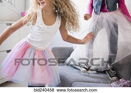Girls wearing tutus dancing on sofa View Large Photo Image Stock Photo - Girls wearing tutus dancing on sofa. Fotosearch
