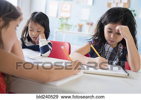 Girls writing in notebooks in school View Large Photo Image Stock Photo - Girls writing in notebooks in school. Fotosearch