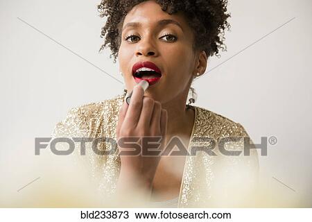 Glamorous Black woman applying red lipstick View Large Photo Image Stock Image - Glamorous Black woman applying red lipstick. Fotosearch
