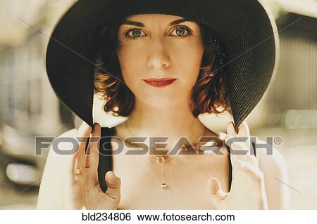 Glamorous Caucasian woman holding hat View Large Photo Image Stock Photograph - Glamorous Caucasian woman holding hat. Fotosearch