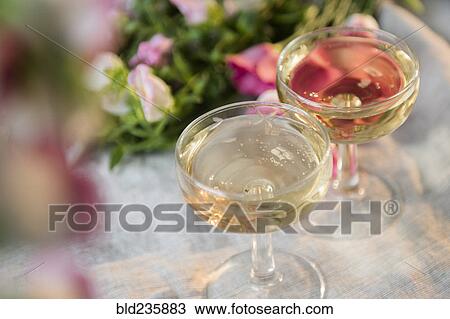 Glasses of champagne near flowers View Large Photo Image Stock Image - Glasses of champagne near flowers. Fotosearch
