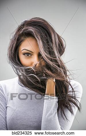 Stock Photography - Hair blowing in face of Indian woman. Fotosearch