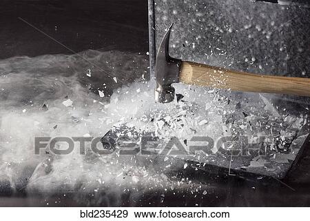 Stock Photo - Hammer breaking ice on frozen laptop. Fotosearch