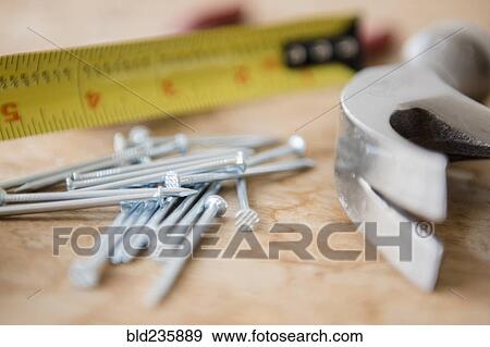 Stock Photo - "Hammer, nails and tape measure on table". Fotosearch
