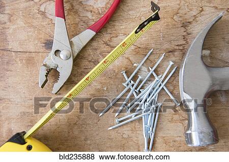 Stock Photo - "Hammer, nails, tape measure and pliers on table". Fotosearch