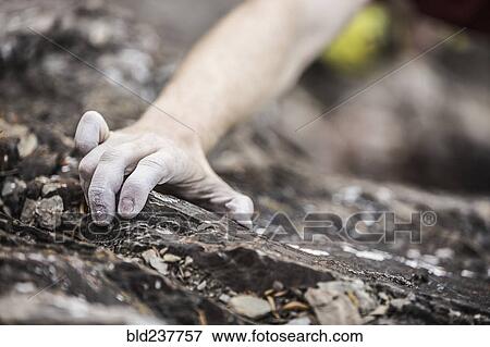 Stock Photo - Hand of Caucasian man rock climbing. Fotosearch