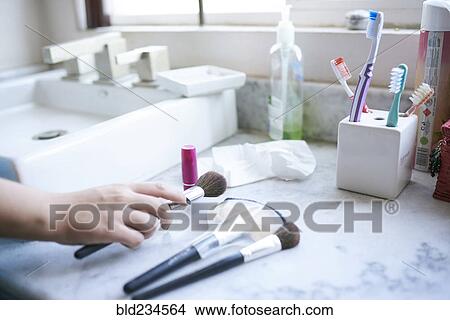 Picture - Hand of Hispanic woman holding makeup brush. Fotosearch