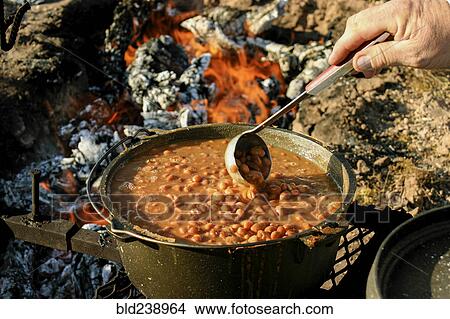 Hand of man stirring beans with ladle on campfire View Large Photo Image Picture - Hand of man stirring beans with ladle on campfire. Fotosearch