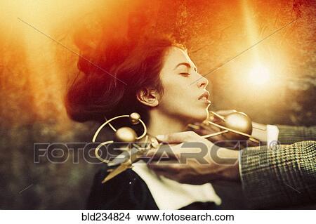 Hands holding metal circle around neck of Caucasian woman View Large Photo Image Picture - Hands holding metal circle around neck of Caucasian woman. Fotosearch