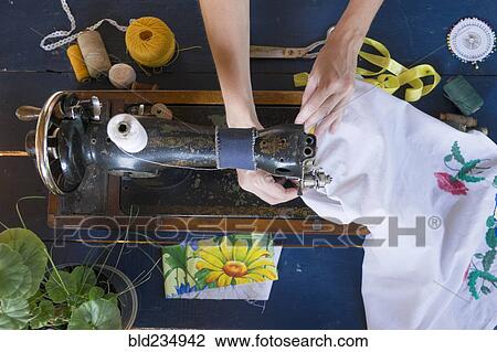 Stock Image - Hands of Caucasian woman using sewing machine. Fotosearch
