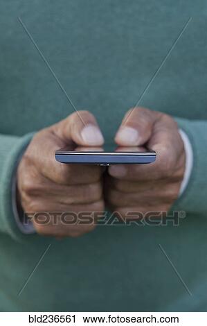 Hands of Hispanic man texting on cell phone View Large Photo Image Stock Image - Hands of Hispanic man texting on cell phone. Fotosearch