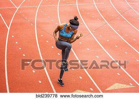 Stock Photo - Happy Black athlete celebrating on track. Fotosearch