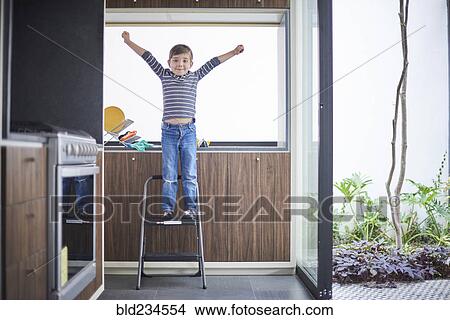 Hispanic boy cheering on ladder View Large Photo Image Picture - Hispanic boy cheering on ladder. Fotosearch