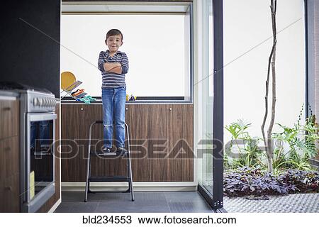 Hispanic boy standing on ladder View Large Photo Image Stock Image - Hispanic boy standing on ladder. Fotosearch