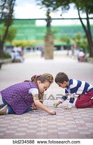 Hispanic brother and sister drawing on sidewalk with chalk View Large Photo Image Stock Photo - Hispanic brother and sister drawing on sidewalk with chalk. Fotosearch