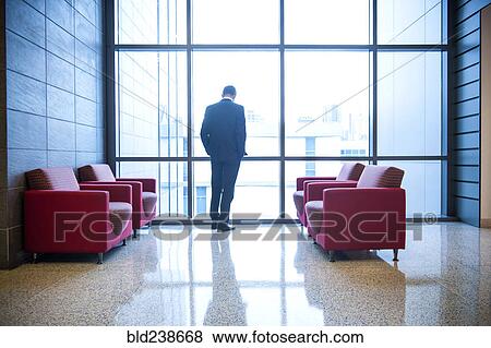 Hispanic businessman waiting in office lounge near window View Large Photo Image Stock Photo - Hispanic businessman waiting in office lounge near window. Fotosearch