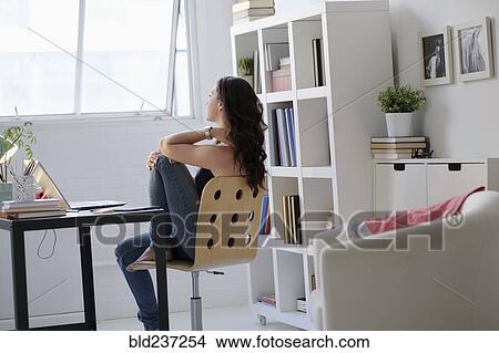 Hispanic businesswoman daydreaming in office View Large Photo Image Picture - Hispanic businesswoman daydreaming in office. Fotosearch