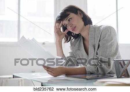 Hispanic businesswoman reading paperwork View Large Photo Image Stock Image - Hispanic businesswoman reading paperwork. Fotosearch