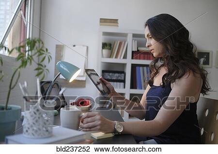 Hispanic businesswoman using digital tablet in office View Large Photo Image Stock Image - Hispanic businesswoman using digital tablet in office. Fotosearch