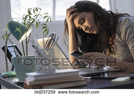 Stock Photo - Hispanic businesswoman using technology in office. Fotosearch