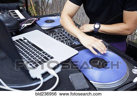 Stock Photograph - Hispanic dj playing music in backyard. Fotosearch