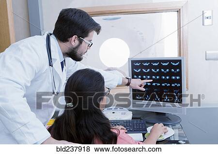Stock Photo - Hispanic doctor and nurse examining scanner results. Fotosearch