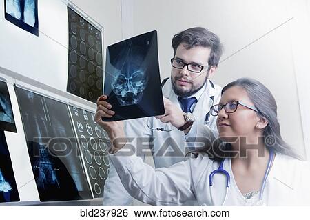 Stock Photograph - Hispanic doctors examining x-rays. Fotosearch