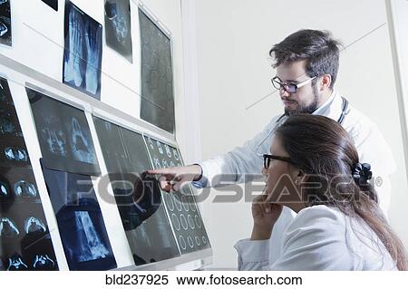 Stock Photography - Hispanic doctors examining x-rays. Fotosearch