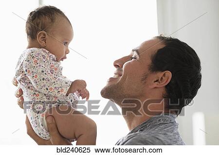 Hispanic father lifting baby daughter View Large Photo Image Stock Photography - Hispanic father lifting baby daughter. Fotosearch