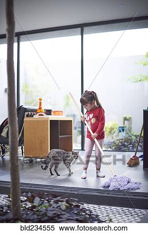 Hispanic girl watching cat and mopping floor View Large Photo Image Stock Photography - Hispanic girl watching cat and mopping floor. Fotosearch