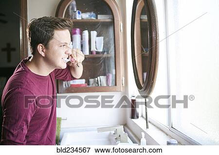 Hispanic man brushing teeth in mirror View Large Photo Image Stock Photo - Hispanic man brushing teeth in mirror. Fotosearch