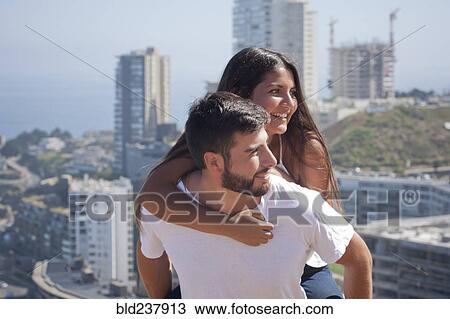 Hispanic man carrying woman piggyback in city View Large Photo Image Stock Image - Hispanic man carrying woman piggyback in city. Fotosearch