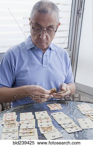 Hispanic man playing card game View Large Photo Image Stock Photography - Hispanic man playing card game. Fotosearch