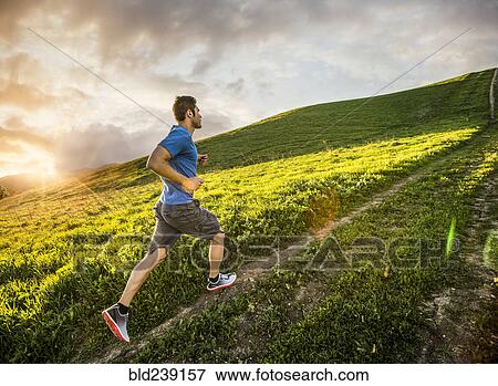 Stock Photo - Hispanic man running on hill. Fotosearch