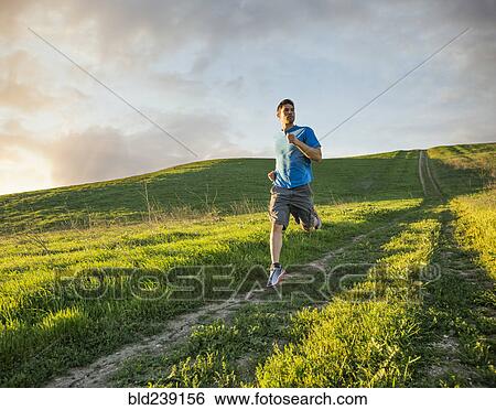 Stock Photograph - Hispanic man running on hill. Fotosearch