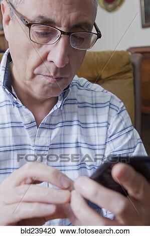 Hispanic man texting on cell phone View Large Photo Image Stock Image - Hispanic man texting on cell phone. Fotosearch