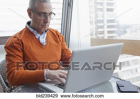 Hispanic man using laptop View Large Photo Image Stock Photo - Hispanic man using laptop. Fotosearch