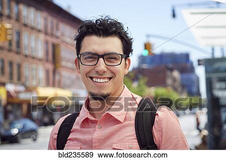 Hispanic man wearing backpack in city View Large Photo Image Stock Photo - Hispanic man wearing backpack in city. Fotosearch