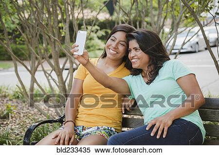 Hispanic mother and daughter posing for cell phone selfie View Large Photo Image Stock Photography - Hispanic mother and daughter posing for cell phone selfie. Fotosearch
