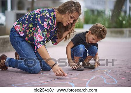 Hispanic mother and son drawing on sidewalk with chalk View Large Photo Image Stock Photo - Hispanic mother and son drawing on sidewalk with chalk. Fotosearch