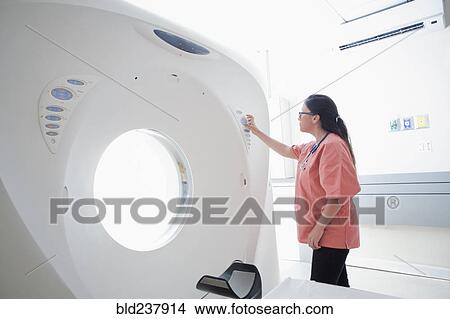 Picture - Hispanic nurse checking scanner. Fotosearch
