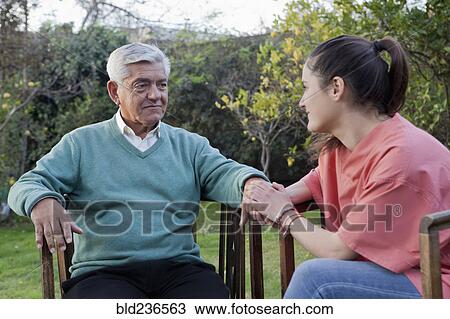 Hispanic nurse comforting man sitting in chair View Large Photo Image Stock Image - Hispanic nurse comforting man sitting in chair. Fotosearch